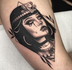 a woman's face with an arrow tattoo on her thigh and headdress