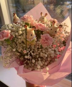 a bouquet of flowers with little deer figurines in it