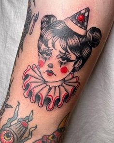 a close up of a person's leg with tattoos on it and an image of a clown