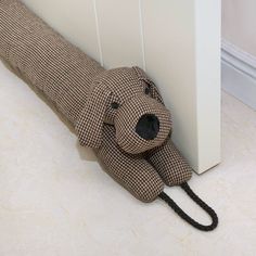 a stuffed dog is tied to the side of a wall