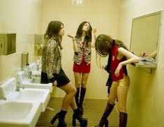 three young women standing in a bathroom next to each other