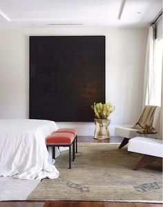 a bedroom with a large painting on the wall next to a bed and two chairs