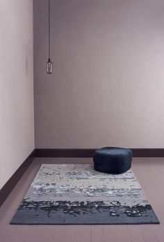 a blue ottoman sitting on top of a wooden floor next to a white and black rug