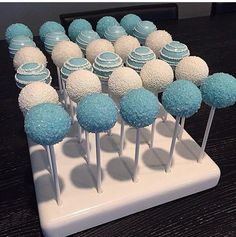 there are many blue and white cupcakes on the cake stand with each one