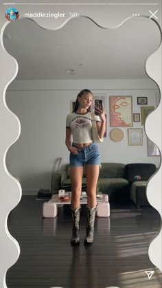 a woman is taking a selfie in front of a mirror with her legs crossed