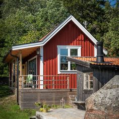 a small red house with a porch next to it