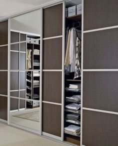 a closet with mirrored doors and shelves filled with folded clothes on top of carpeted flooring