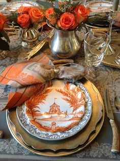 an elegant table setting with orange roses and silverware