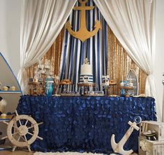 a table covered in blue and white decorations with an anchor on it's side