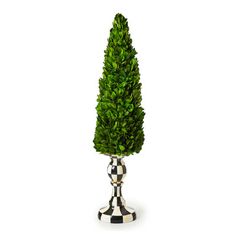 a small potted tree in a checkered vase on a white background with black and white stripes