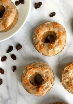 six doughnuts on a marble table with raisins