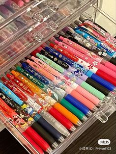 a clear container filled with lots of different colored pens