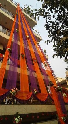 an orange and purple decoration on the side of a tall building with lots of windows