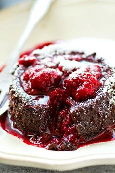 a chocolate cake with raspberry sauce on a white plate