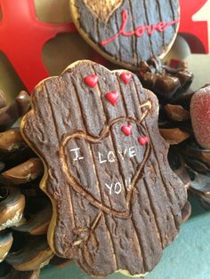 two decorated cookies sitting on top of a table next to pine cones and other decorations