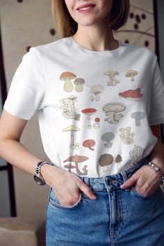 This super mushroom botanical t shirt has a very soft, loose fit! So comfy and trendy for a casual look. Roll the sleeves up, tie on the side for a cropped look and style with high waist denim bottoms and combat boots or sneakers! ------------------------------------------------------------------------------------------------------------------------------------------------- * 100% ring-spun cotton * 4.5 oz/y² (153 g/m²) * Pre-shrunk * Shoulder-to-shoulder taping * Quarter-turned to avoid crease Cottagecore Tops, Mushroom Sweater, Cottage Core Shirt, Alt Clothing, Cottagecore Mushroom, Mushroom Shirt, Cottagecore Clothes, Alt Clothes, Cottagecore Shirt