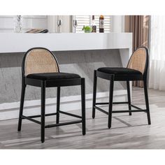 two black chairs with wicker backrests in front of a white counter top