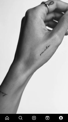 a person's hand with a small tattoo on the left side of their arm