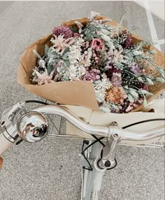 a bouquet of flowers sitting on the back of a bicycle