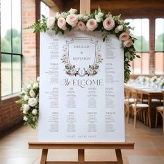 a wedding seating sign with flowers and greenery