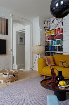 a living room filled with furniture next to a book shelf covered in lots of books