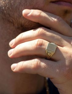 a close up of a person wearing a gold ring