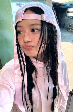 a girl with long hair wearing a pink raincoat