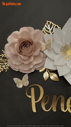 paper flowers with gold lettering and butterflies on a black background that says pennelu