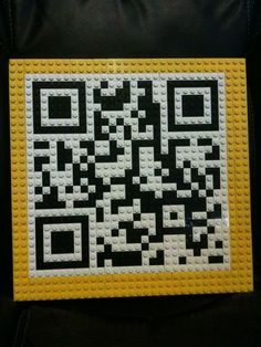 a yellow and black lego block with a qr code printed on it's side