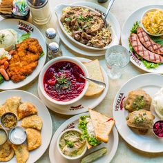 a table topped with lots of plates filled with different types of food and condiments