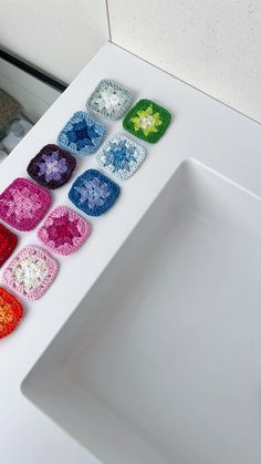 there are many crocheted squares on the counter in front of the bathroom sink