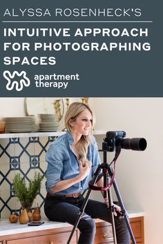 a woman sitting on top of a wooden table next to a camera