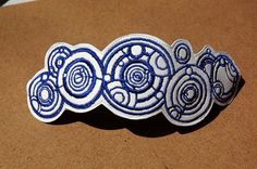 three blue and white decorative objects sitting on top of a brown surface in front of a cardboard box