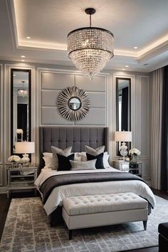 a large bed sitting in a bedroom under a chandelier