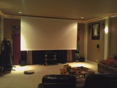 a living room with a large projection screen in the middle of it's wall