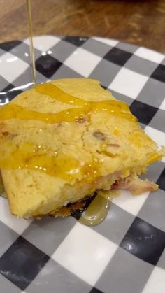 a piece of food sitting on top of a white and black checkerboard plate