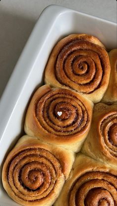 several cinnamon rolls in a white baking dish