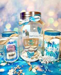 there are three glass jars with pictures in them on the table next to shells and seashells