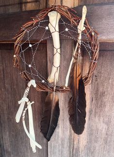 a wreath with feathers and chains hanging from it