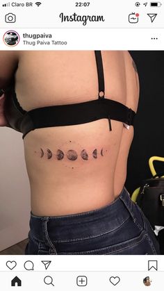 a woman's stomach with the phases of planets tattooed on her side, and an inscription