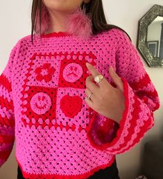 The newest addition to the Lucy Collection - a handmade to order crochet jumper! This pink crochet jumper has been lovingly handmade with a 'mixed emotions' design at the front, featuring happy and sad faces, a love heart and a flower, with checkered details - each design will be slightly different and unique. The sleeves are striped pink and red, and extra-long for that cosy oversized jumper feeling. A bright pink and red jumper for anyone that loves colour and wearing slow fashion. Crochet Jumper, Red Jumper, Mixed Emotions, Pink Crochet, Oversized Jumper, Pink And Red, Jumpers And Cardigans, Festival Outfits, A Flower