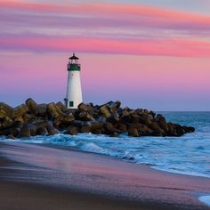 a light house sitting on top of a rocky beach