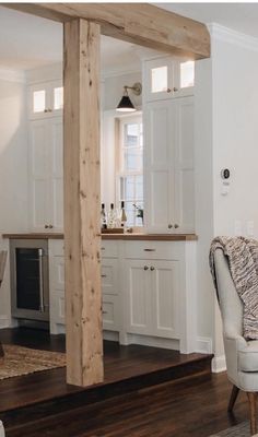 a living room filled with furniture next to a kitchen