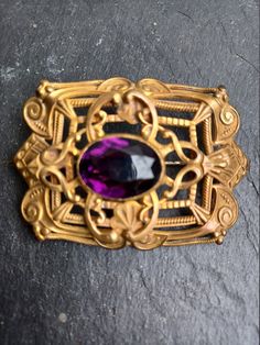 Large vintage Art Nouveau brooch. Beautiful elaborate repousse design with faceted purple gem in the middle. Original C clasp on the back. Please note there is some wear to the setting and stone consistent with age. Purple Gems, Crystal Candle Holder, Wood Puzzles, Candy Bowl, Crystal Candles, Purple Stones, Lovely Necklace, Wine Cooler, Large Art