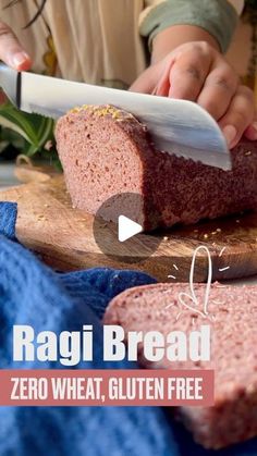 a person cutting meat with a knife on top of a wooden board next to another piece of bread