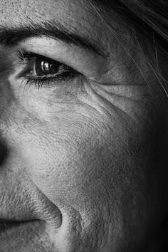 black and white photograph of a woman's face with wrinkles on her eyes