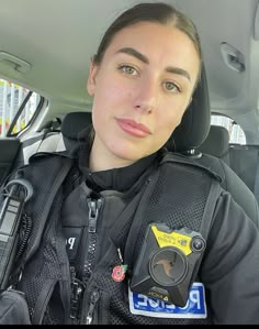 a female police officer sitting in the back seat of a car with her camera attached to her chest