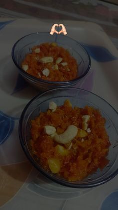 two bowls filled with food on top of a table