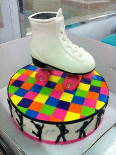 a cake decorated with colorful squares and skates on top of eachother's feet