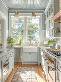 a kitchen with blue walls and white cabinets, an oven, dishwasher and sink